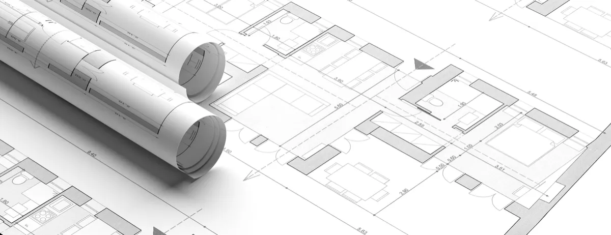 Rolled architectural blueprints on top of building plans